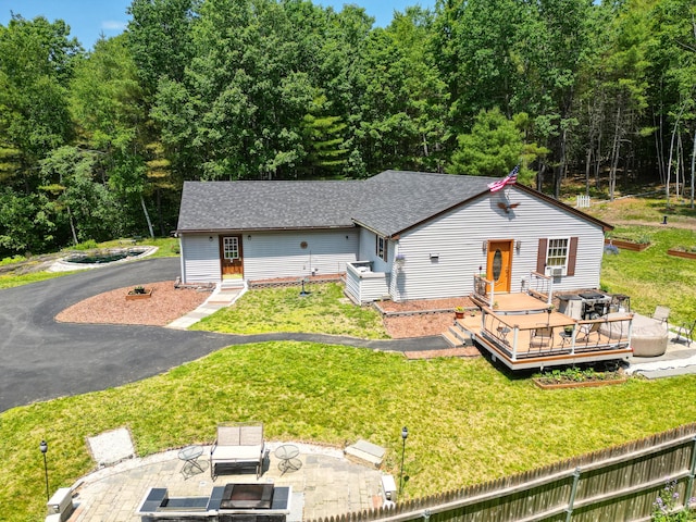 10 Tenacious Way, Augusta, ME 04330 - bungalow with an outdoor fire pit, a wooden deck, a front yard, and a shingled roof
