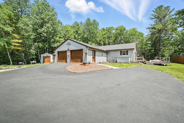 10 Tenacious Way, Augusta, ME 04330 - view of front of house with asphalt driveway, a garage, view of scattered trees, and a storage shed