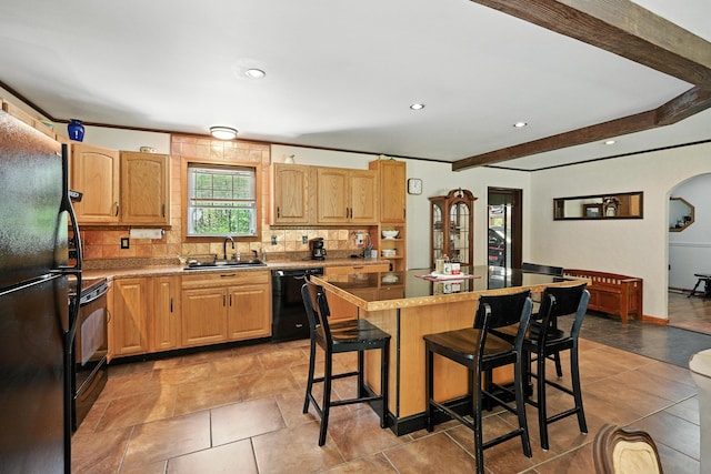 10 Tenacious Way, Augusta, ME 04330 - kitchen featuring black appliances, a breakfast bar area, tasteful backsplash, a kitchen island, and arched walkways
