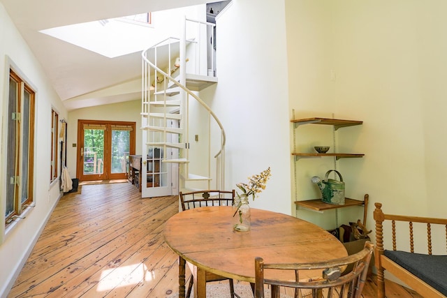 265 Greenacre Rd, Lincolnville, ME 04849 - dining room with a skylight, light wood-type flooring, vaulted ceiling, and french doors