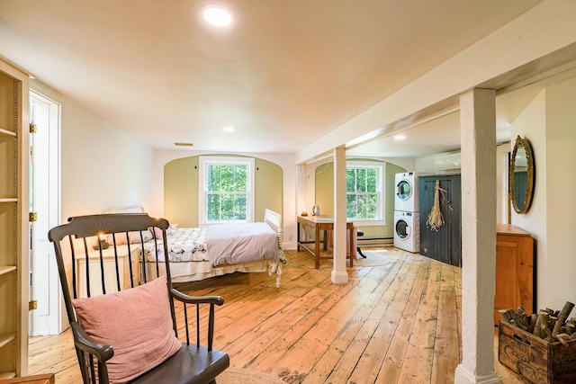 265 Greenacre Rd, Lincolnville, ME 04849 - bedroom featuring stacked washing machine and dryer, arched walkways, light wood-type flooring, recessed lighting, and a baseboard heating unit