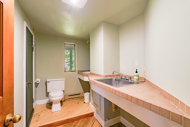 265 Greenacre Rd, Lincolnville, ME 04849 - bathroom featuring a baseboard heating unit, wood finished floors, and vanity