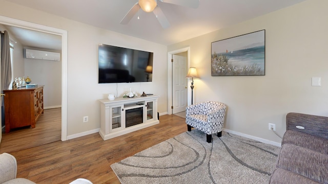 15 Cattail Ln, Monmouth, ME 04259 - living room featuring ceiling fan, wood finished floors, a glass covered fireplace, and a wall mounted AC
