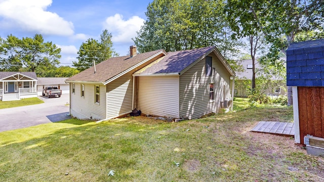 15 Cattail Ln, Monmouth, ME 04259 - view of home's exterior featuring a shingled roof, a yard, and a chimney