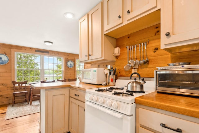 100 Bear Path, Rangeley, ME 04970 - kitchen featuring white appliances, a peninsula, light wood-style floors, and wood walls