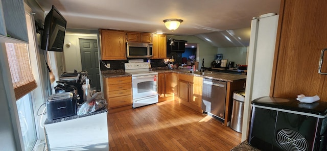 48 Gary St, Paris, ME 04281 - kitchen with stainless steel appliances, light wood-style floors, dark countertops, decorative backsplash, and vaulted ceiling