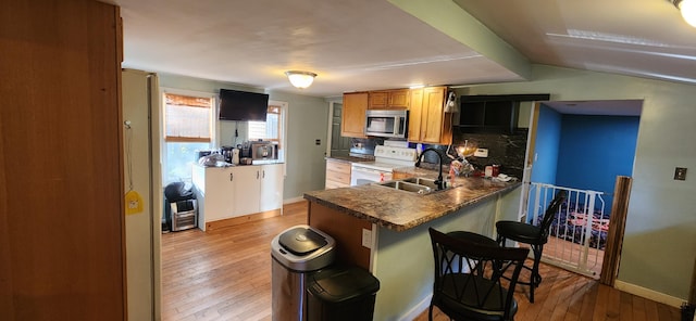 48 Gary St, Paris, ME 04281 - kitchen featuring white electric range, stainless steel microwave, light wood finished floors, a breakfast bar, and a peninsula