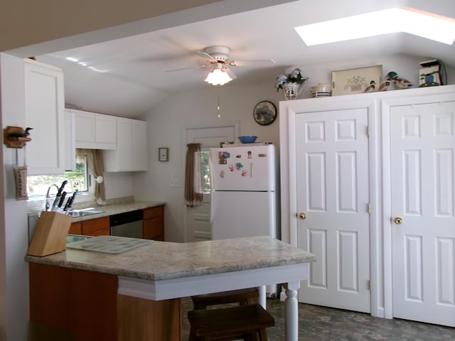 24 Paradise Dr, Monmouth, ME 04259 - kitchen with vaulted ceiling, a skylight, dishwasher, ceiling fan, and a peninsula