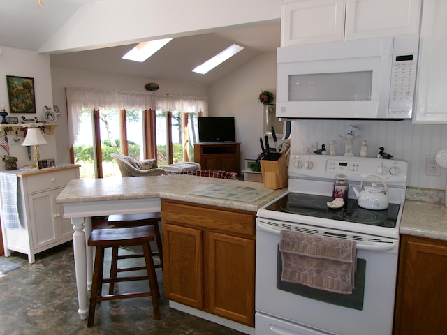 24 Paradise Dr, Monmouth, ME 04259 - kitchen featuring white appliances, lofted ceiling, a skylight, a peninsula, and light countertops
