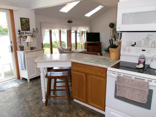 24 Paradise Dr, Monmouth, ME 04259 - kitchen featuring white appliances, lofted ceiling, a skylight, a peninsula, and plenty of natural light
