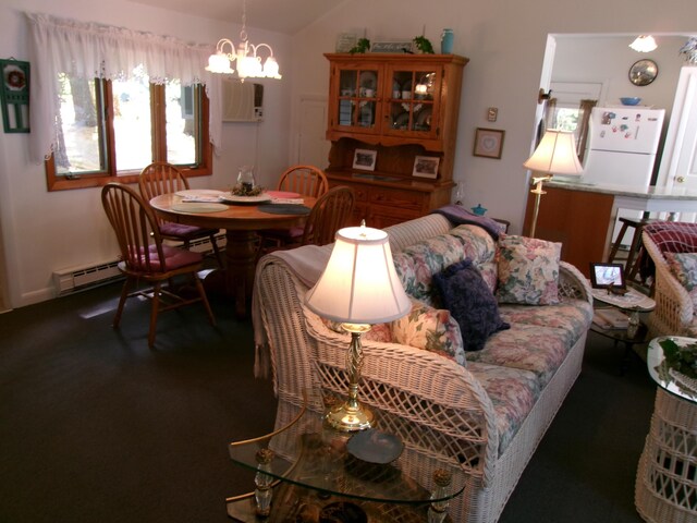 24 Paradise Dr, Monmouth, ME 04259 - living room featuring a baseboard radiator, a chandelier, vaulted ceiling, and carpet floors