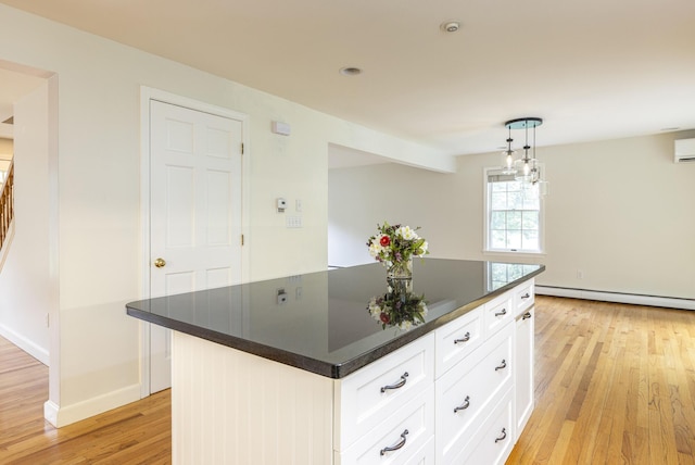 3 Cape Woods Dr Unit 3, Cape Elizabeth, ME 04107 - kitchen with baseboard heating, light wood-style flooring, dark countertops, white cabinets, and a center island