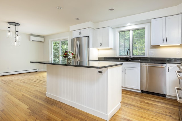 3 Cape Woods Dr Unit 3, Cape Elizabeth, ME 04107 - kitchen featuring stainless steel appliances, a wall unit AC, light wood-style flooring, a baseboard radiator, and dark countertops