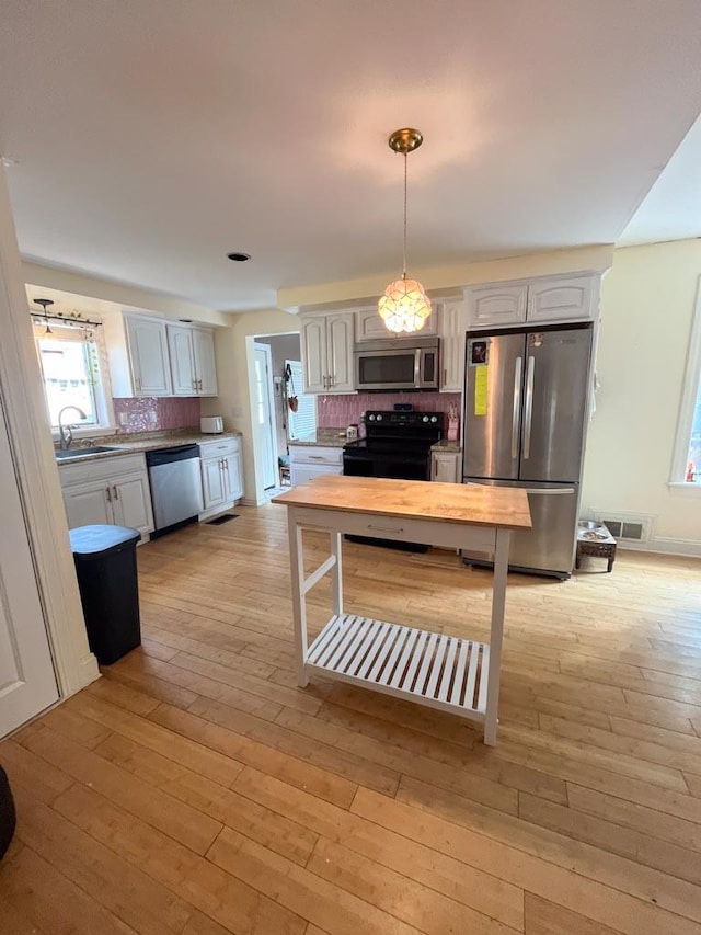 4 E St, Sanford, ME 04073 - kitchen featuring appliances with stainless steel finishes, decorative backsplash, light wood-style flooring, and light countertops
