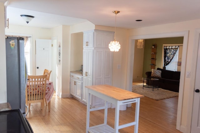4 E St, Sanford, ME 04073 - kitchen featuring freestanding refrigerator, light wood finished floors, decorative light fixtures, and a chandelier