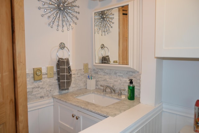 87 Perch Pt, Shapleigh, ME 04076 - bathroom with vanity, a wainscoted wall, a chandelier, a decorative wall, and backsplash