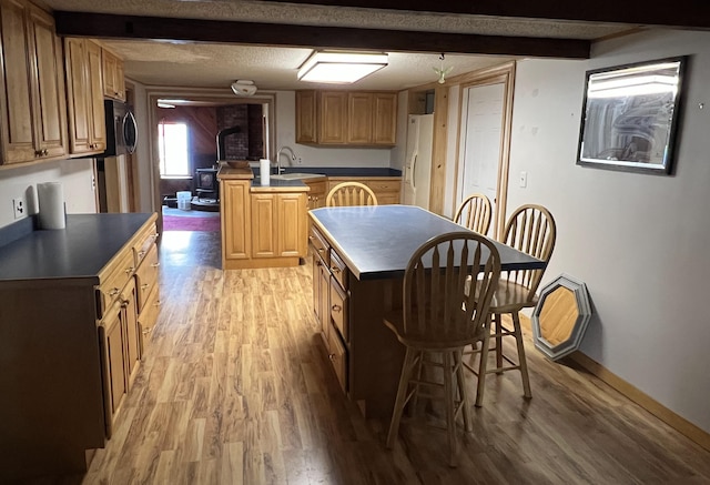 257 N Ave, Skowhegan, ME 04976 - kitchen with freestanding refrigerator, light wood-style flooring, dark countertops, a peninsula, and a kitchen island