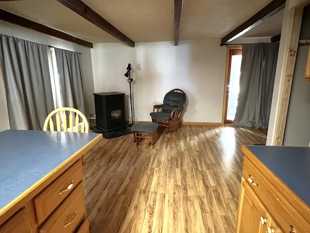 257 N Ave, Skowhegan, ME 04976 - living room with beamed ceiling, light wood-style floors, and a wood stove
