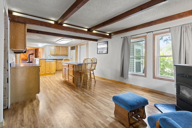 257 N Ave, Skowhegan, ME 04976 - dining room featuring a wood stove, a textured ceiling, light wood-type flooring, and beam ceiling
