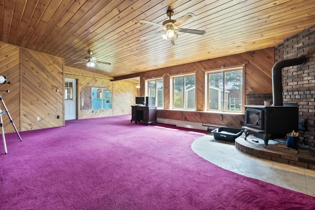 257 N Ave, Skowhegan, ME 04976 - carpeted living room featuring a wood stove, ceiling fan, wooden ceiling, and wooden walls