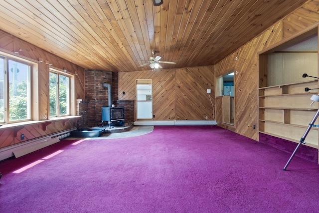 257 N Ave, Skowhegan, ME 04976 - unfurnished room with a wood stove, carpet floors, wood walls, ceiling fan, and wooden ceiling