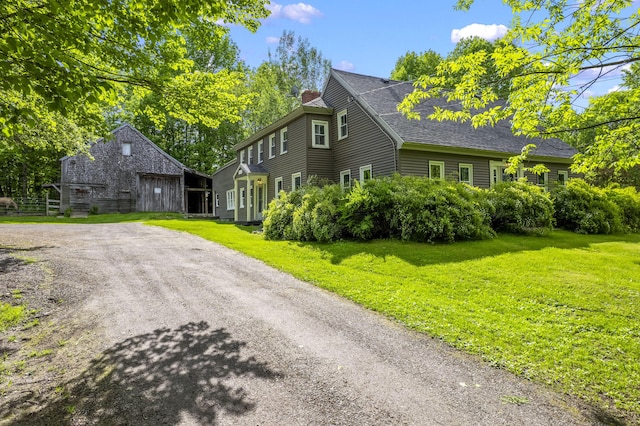 1548 Main St, Readfield, ME 04355 - view of front of property featuring a chimney, a front yard, an outdoor structure, and a shingled roof