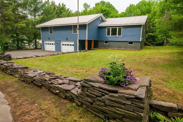 44 Donigan Rd, Moscow, ME 04920 - rear view of property featuring an attached garage, driveway, a metal roof, and a lawn