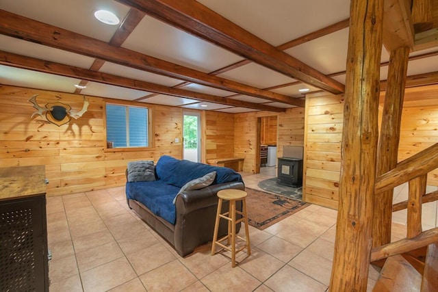 44 Donigan Rd, Moscow, ME 04920 - living area featuring wood walls, beamed ceiling, a wood stove, and light tile patterned floors