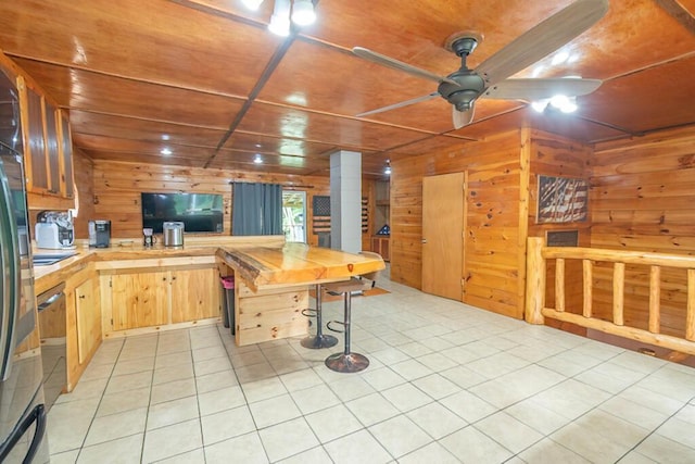 44 Donigan Rd, Moscow, ME 04920 - kitchen with a ceiling fan, wooden walls, light countertops, light tile patterned flooring, and a peninsula