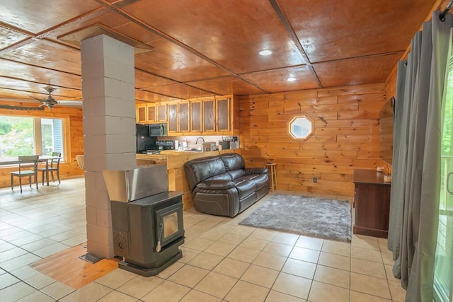 44 Donigan Rd, Moscow, ME 04920 - living area with wooden walls, light tile patterned floors, a wood stove, ceiling fan, and recessed lighting