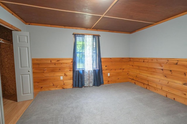 44 Donigan Rd, Moscow, ME 04920 - spare room featuring a wainscoted wall, wooden walls, and crown molding