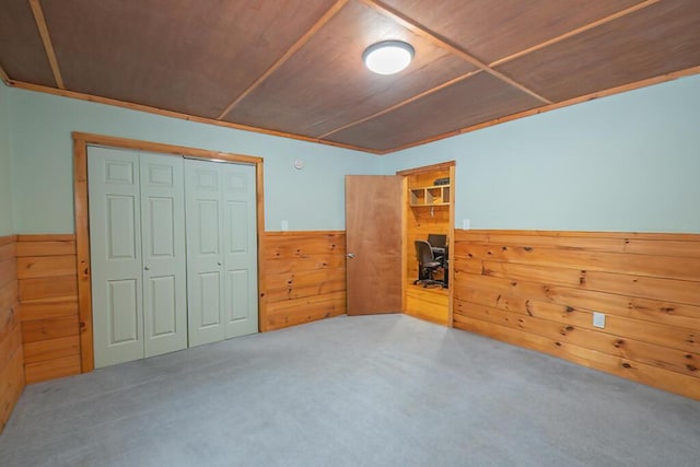 44 Donigan Rd, Moscow, ME 04920 - unfurnished bedroom featuring wood walls, a closet, wainscoting, carpet, and wooden ceiling
