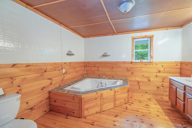 44 Donigan Rd, Moscow, ME 04920 - full bathroom with wood walls, a garden tub, vanity, wood-type flooring, and wainscoting