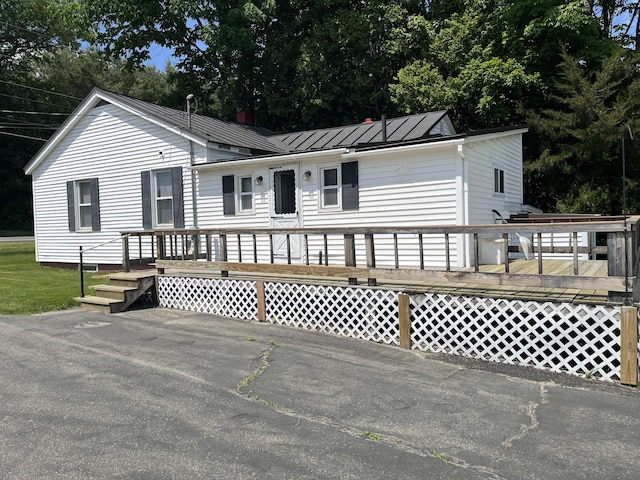 406 Cushman Rd, Winslow, ME 04901 - view of front of home with a metal roof, a wooden deck, and a standing seam roof
