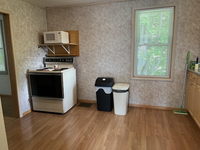 406 Cushman Rd, Winslow, ME 04901 - kitchen with range with electric cooktop, white microwave, light wood-type flooring, plenty of natural light, and ornamental molding