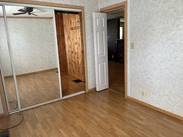 406 Cushman Rd, Winslow, ME 04901 - unfurnished bedroom featuring wallpapered walls, wood finished floors, a closet, and a ceiling fan