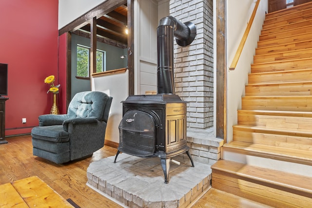8 Holbrook Dr, Phippsburg, ME 04562 - living area with stairs, a wood stove, wood finished floors, and a baseboard radiator