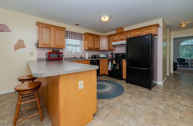 119 Somersworth Rd, North Berwick, ME 03906 - kitchen featuring black appliances, under cabinet range hood, a peninsula, a breakfast bar, and plenty of natural light