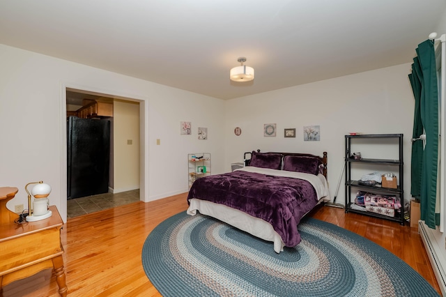 119 Somersworth Rd, North Berwick, ME 03906 - bedroom with freestanding refrigerator, a baseboard radiator, and wood finished floors