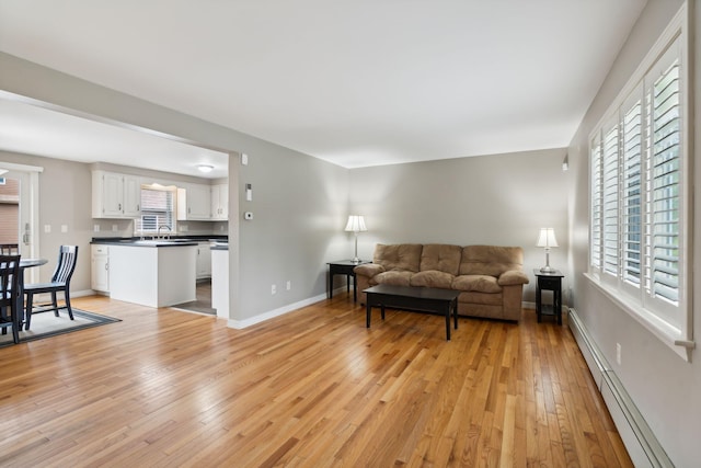 11 Concord Pl Unit 21, Auburn, ME 04210 - living room with a baseboard radiator, light wood-type flooring, and healthy amount of natural light