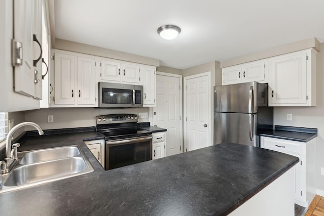 11 Concord Pl Unit 21, Auburn, ME 04210 - kitchen featuring stainless steel appliances, dark countertops, a peninsula, and white cabinetry