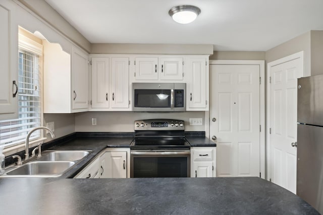 11 Concord Pl Unit 21, Auburn, ME 04210 - kitchen with appliances with stainless steel finishes, dark countertops, and white cabinetry