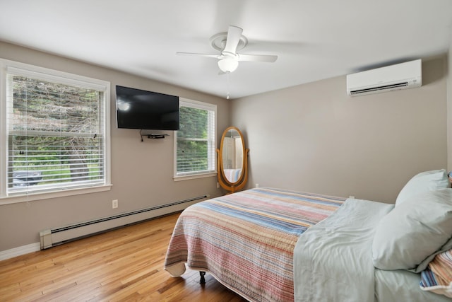 11 Concord Pl Unit 21, Auburn, ME 04210 - bedroom with a wall mounted air conditioner, a baseboard heating unit, wood finished floors, and ceiling fan