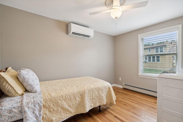 11 Concord Pl Unit 21, Auburn, ME 04210 - bedroom with a wall mounted air conditioner, a baseboard heating unit, light wood-style floors, and a ceiling fan