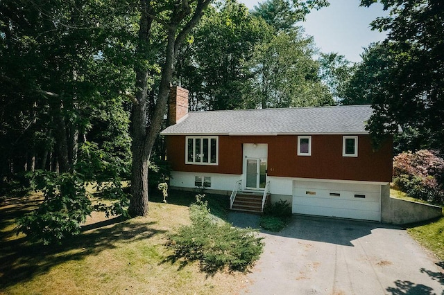 41 Curtis Ln, Milford, ME 04461 - bi-level home with driveway, a garage, a chimney, and roof with shingles