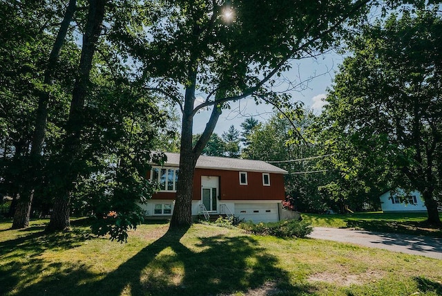41 Curtis Ln, Milford, ME 04461 - split foyer home with driveway, a garage, and a front lawn
