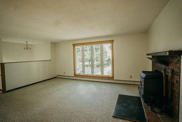 41 Curtis Ln, Milford, ME 04461 - unfurnished living room featuring baseboard heating, a textured ceiling, a chandelier, a wood stove, and carpet