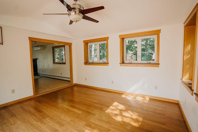 41 Curtis Ln, Milford, ME 04461 - unfurnished room with baseboard heating, wood finished floors, healthy amount of natural light, a wall mounted air conditioner, and lofted ceiling