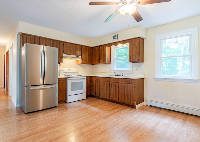 919 College St, Lewiston, ME 04240 - kitchen with freestanding refrigerator, white range with electric stovetop, under cabinet range hood, light countertops, and light wood-type flooring