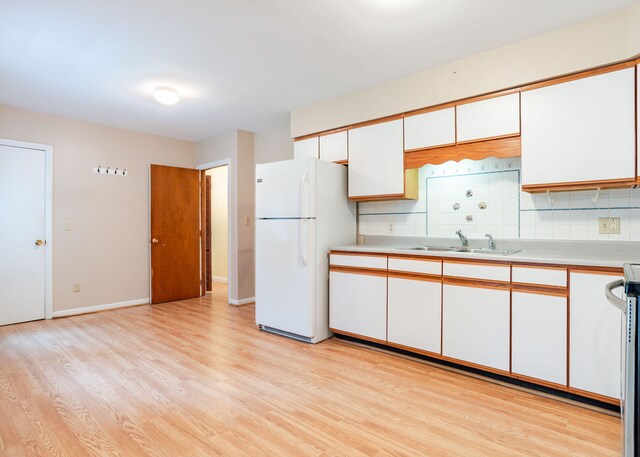 919 College St, Lewiston, ME 04240 - kitchen featuring freestanding refrigerator, light wood finished floors, light countertops, decorative backsplash, and white cabinetry